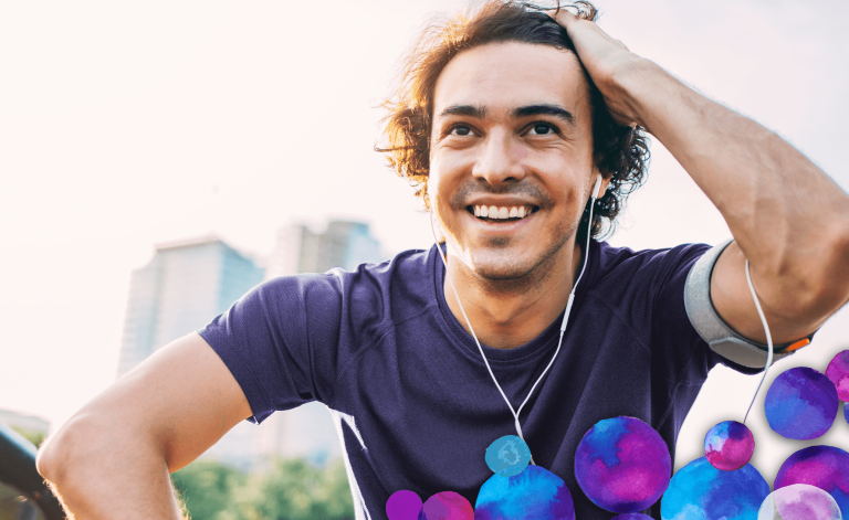 man smiling with earphones outdoors