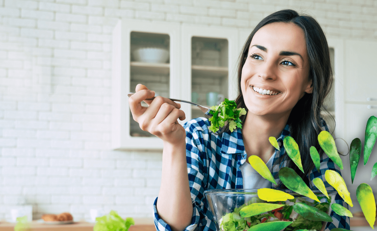 woman smiling and eating a salad