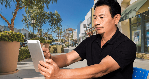 mature man holding a tablet and smiling